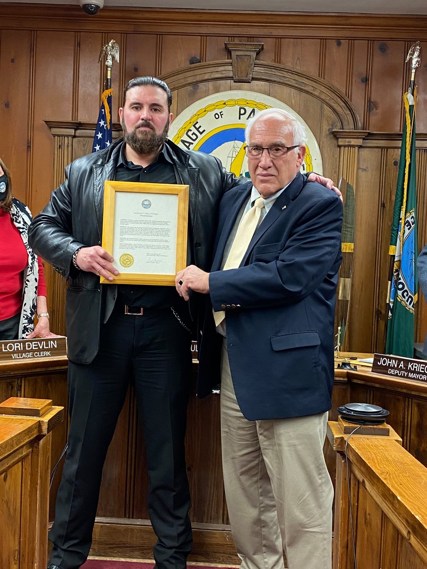 Patchogue Village Mayor Paul Pontieri honors former United States Marine Guillermo Sandoval with a Proclamation during a Village meeting on Monday.